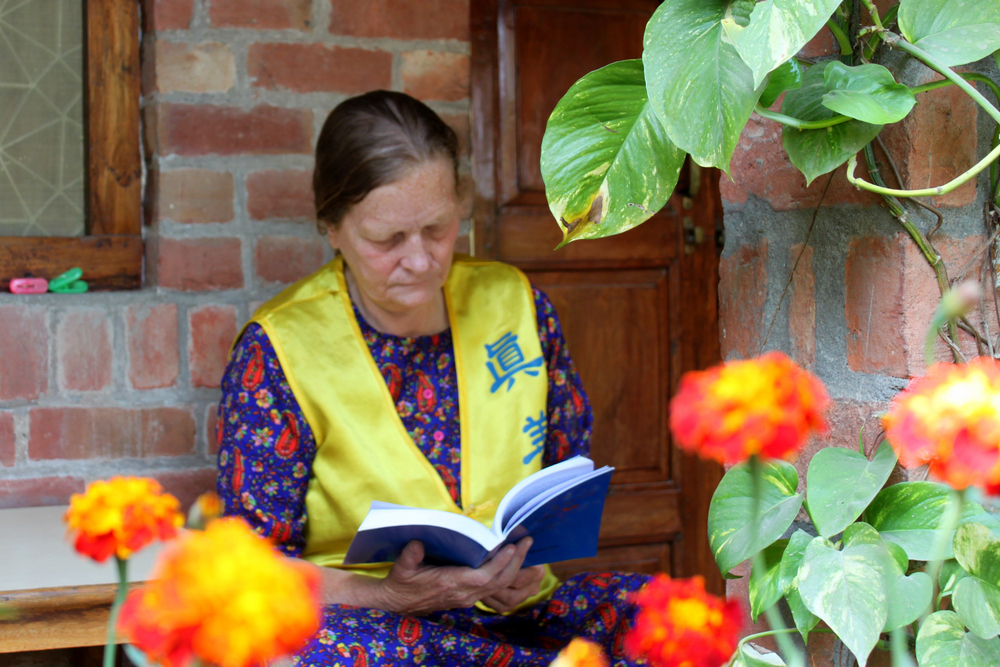 Chris čita Zhuan Falun, glavnu knjigu Falun Dafa. (Zaslugom: Venus Upadhayaya/NTD)