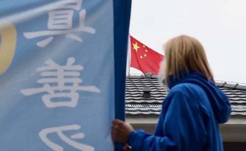 Srpska Falun Gong praktikantica drži transparent ispred kineske ambasade u Beogradu (Minghui.org, 2019.)