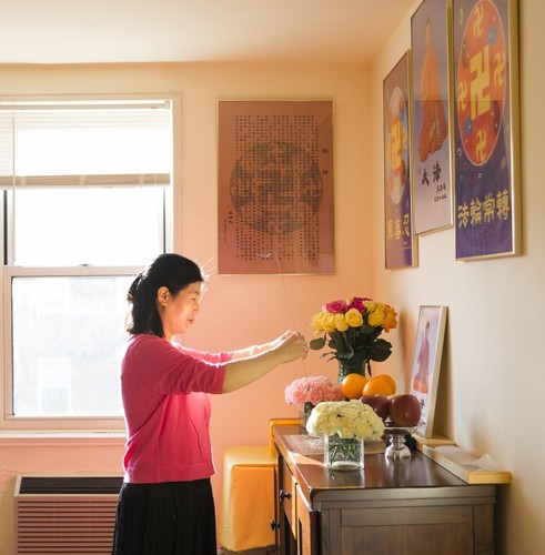Wang Huijuan iskazuje poštovanje osnivaču Falun Gonga u svojoj kući u Queensu, u New Yorku, 8. siječnja 2016. godine. Sa svojim suprugom i kćerkom, pobjegla je iz Kine 2014. godine i dobila je azil nakon godina mučenja zbog prakticiranja Falun Gonga. (Samira Bouaou / Epoch Times)