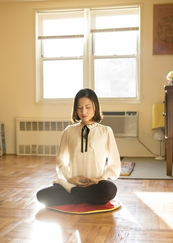 Li Fuyao pokazuje svoju meditativnu praksu u svojoj kući u Queensu, u New Yorku, 8. siječnja 2016. godine. Ona i njeni roditelji pobjegli su iz Kine 2014. godine i dobili su azil nakon godina mučenja zbog prakticiranja Falun Gonga. (Samira Bouaou / Epoch Times)