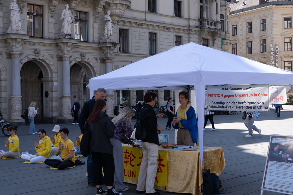 Viele Passanten unterschreiben die G7+7 Petition gegen Organraub in China. Foto: FDI